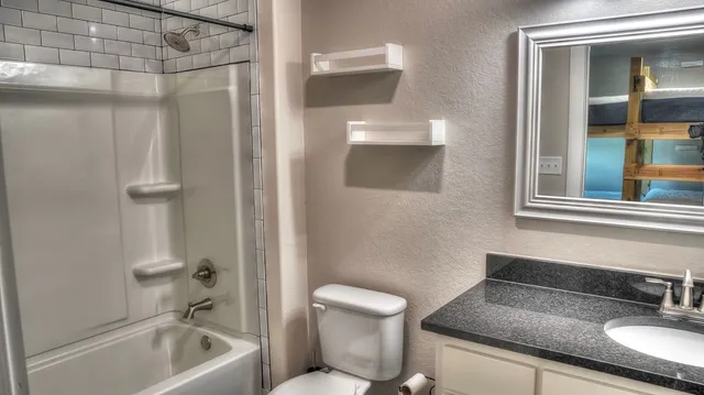 a bathroom with a granite countertop sink toilet and shower
