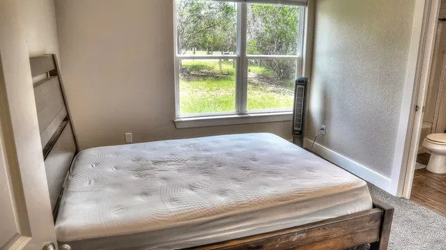 a bedroom with a bed and a window