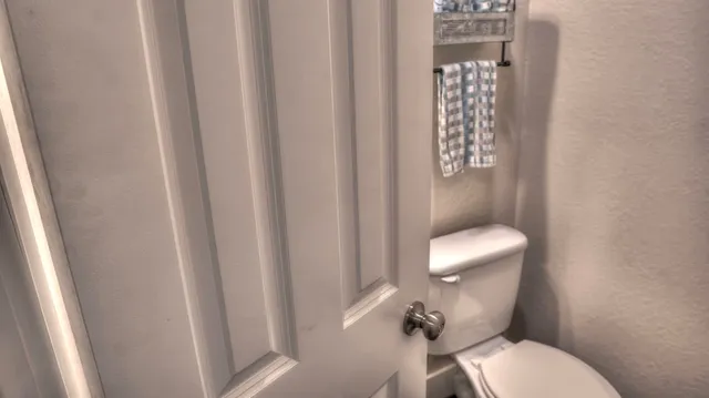 a white toilet sitting next to a small window