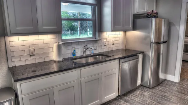 a kitchen with stainless steel appliances granite countertop a sink and a window