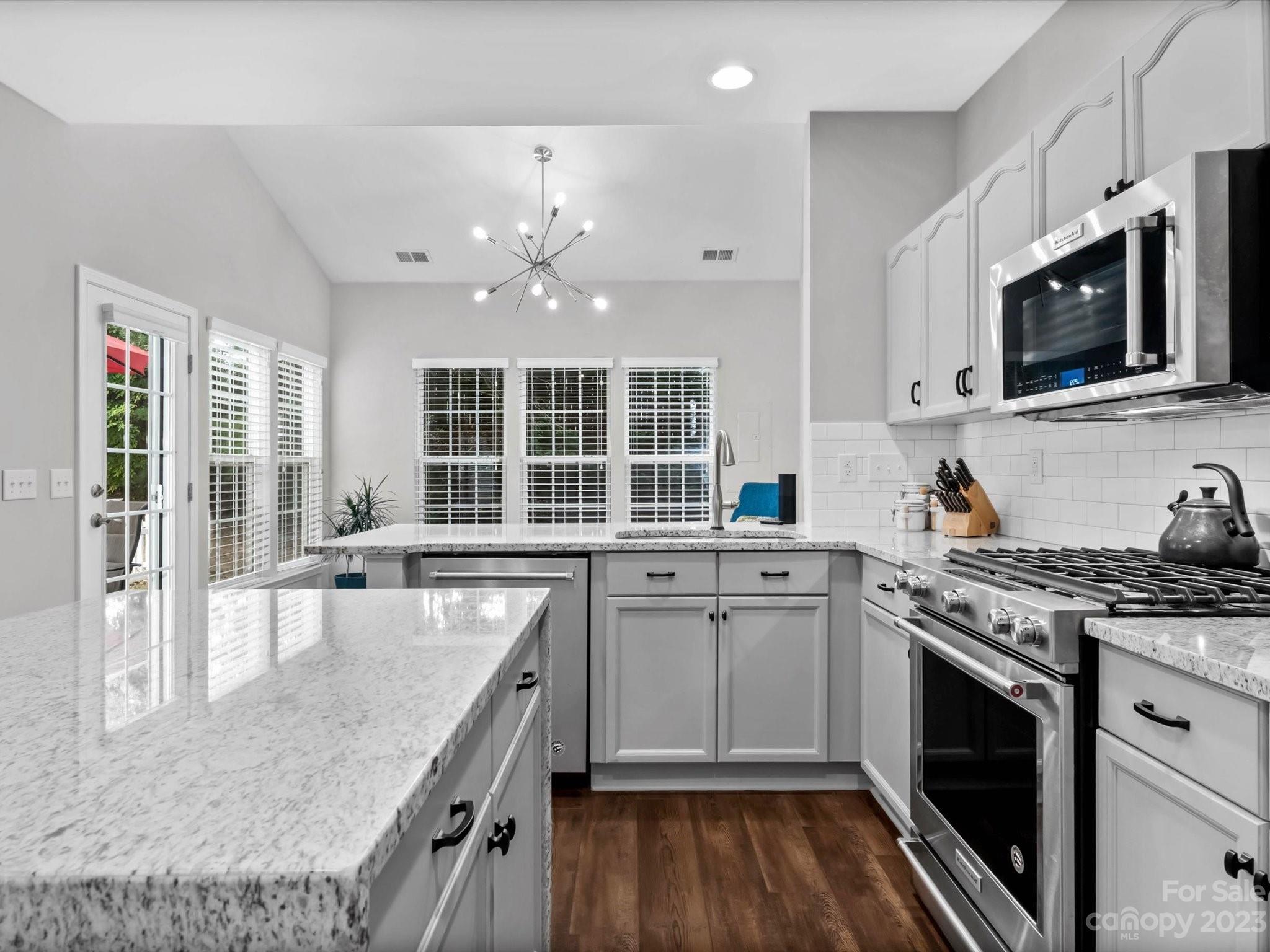 a kitchen with stainless steel appliances granite countertop a stove and a sink