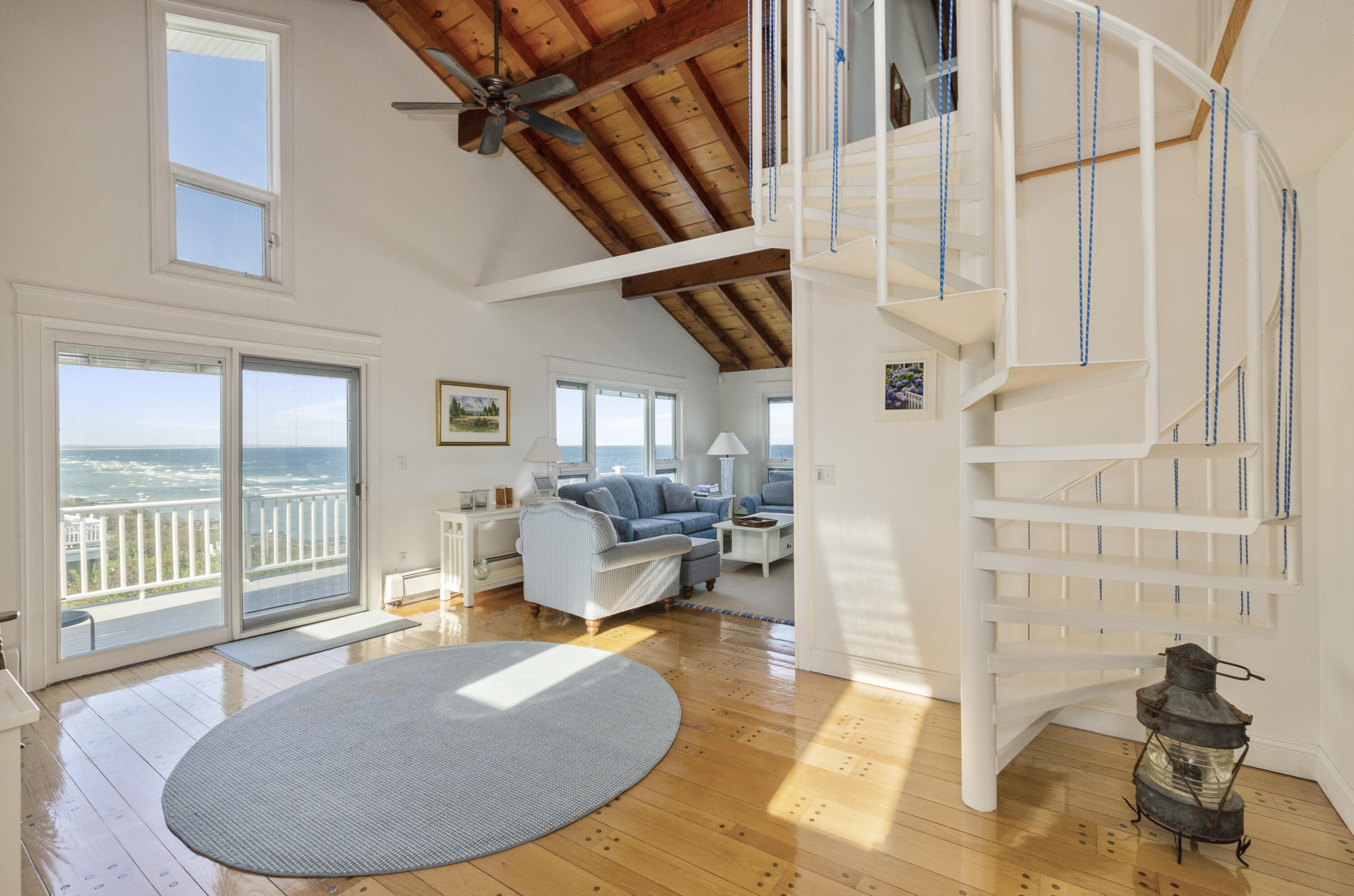 96 Shore Drive Dennis, MA 02638 - Photo 12 of 37 a living room with couches a fireplace and a large window with wooden floor