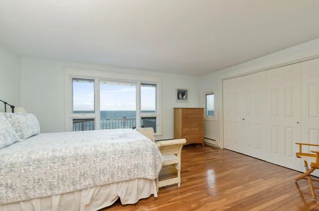 a spacious bedroom with a bed and a wooden floor