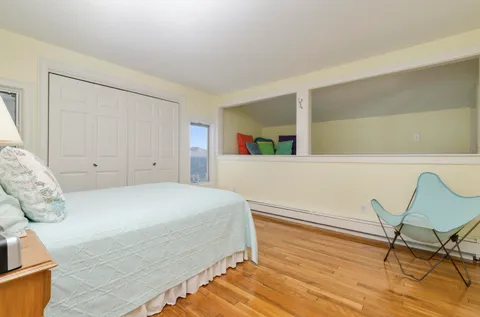 a bedroom with a bed and wooden floor