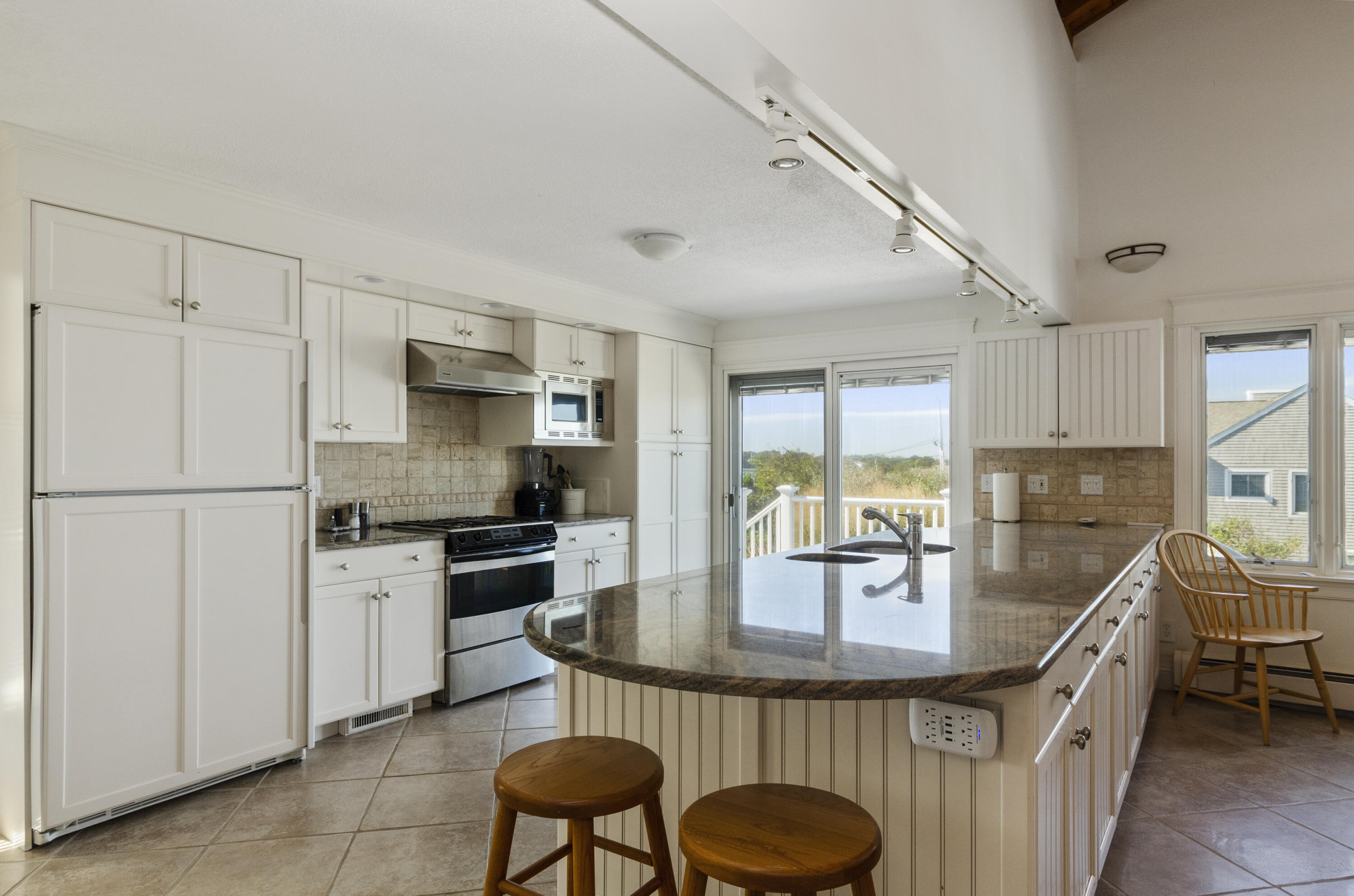 96 Shore Drive Dennis, MA 02638 - Photo 4 of 37 a kitchen with kitchen island granite countertop a sink stainless steel appliances and cabinets