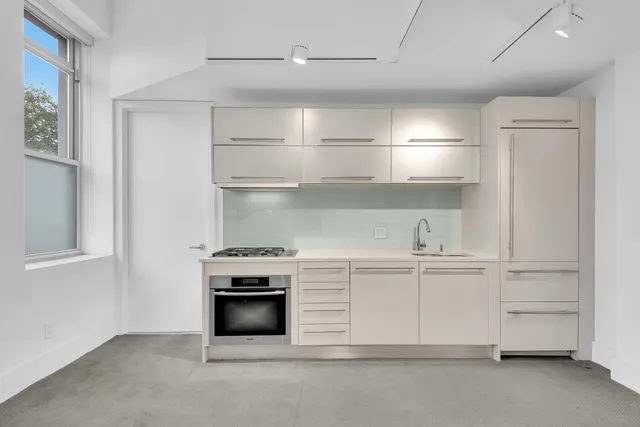 a kitchen with white cabinets and a stove