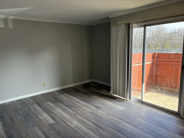 an empty room with wooden floor and door