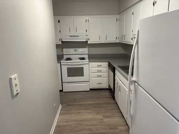 a kitchen with white cabinets and white appliances