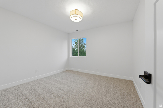 702 Alpine Highway Alpine, UT 84004 - Photo 46 of 83 Bright room featuring light neutral carpeting, white walls, a single window, and a flush mount ceiling light fixture