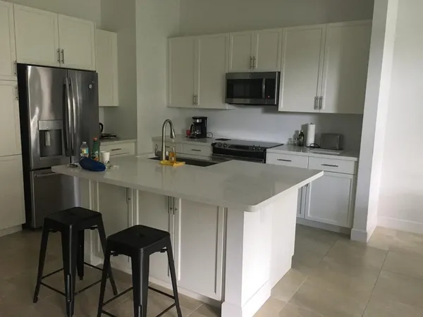 a kitchen with stainless steel appliances a stove a sink refrigerator and microwave