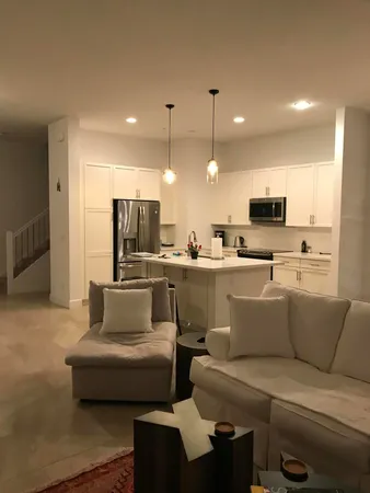 a living room with furniture and kitchen view