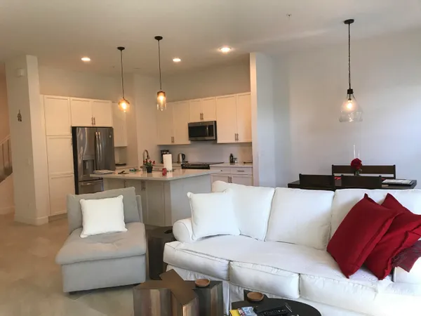 a living room with a couch and a view of kitchen