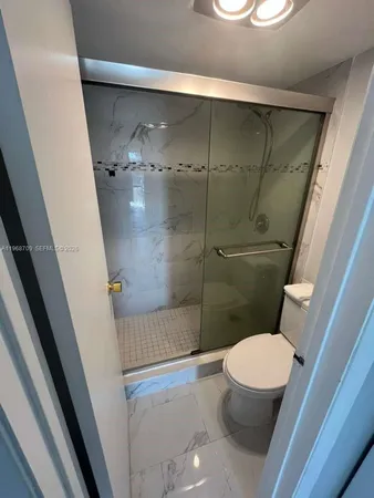 a bathroom with a toilet and a shower