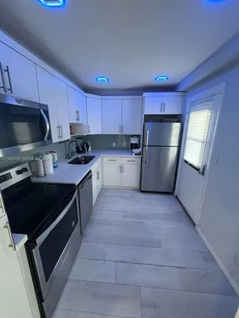 a kitchen with a refrigerator a stove a microwave and cabinets