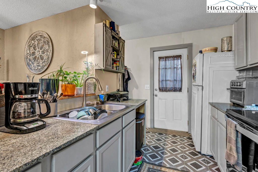 180 Wild Blackberry Hill Road Boone, NC 28607 - Photo 10 of 30 a kitchen with sink a stove and a clock