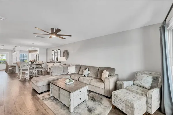 a living room with furniture and a wooden floor