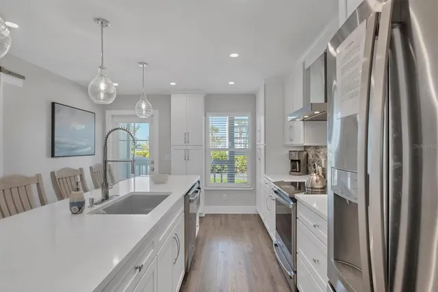 a large kitchen with kitchen island a stove a sink a chimney and cabinets