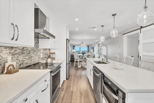 a kitchen with a sink appliances and wooden floor