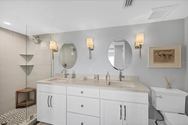 a bathroom with a granite countertop sink a mirror and shower