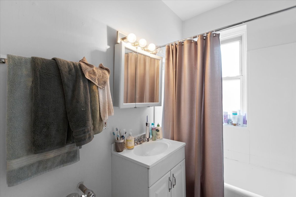 2453 North Clark Street, Unit 3 Chicago, IL 60614 - Photo 10 of 11 a bathroom with a sink vanity and mirror