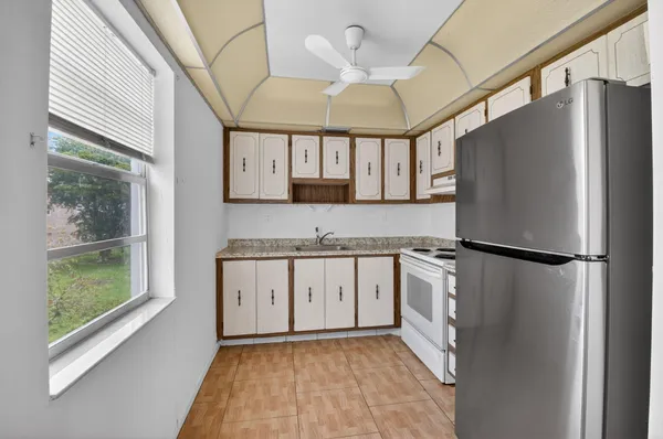 a kitchen with stainless steel appliances granite countertop white cabinets stove a sink and dishwasher