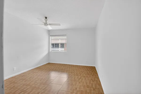 an empty room with windows and cabinet