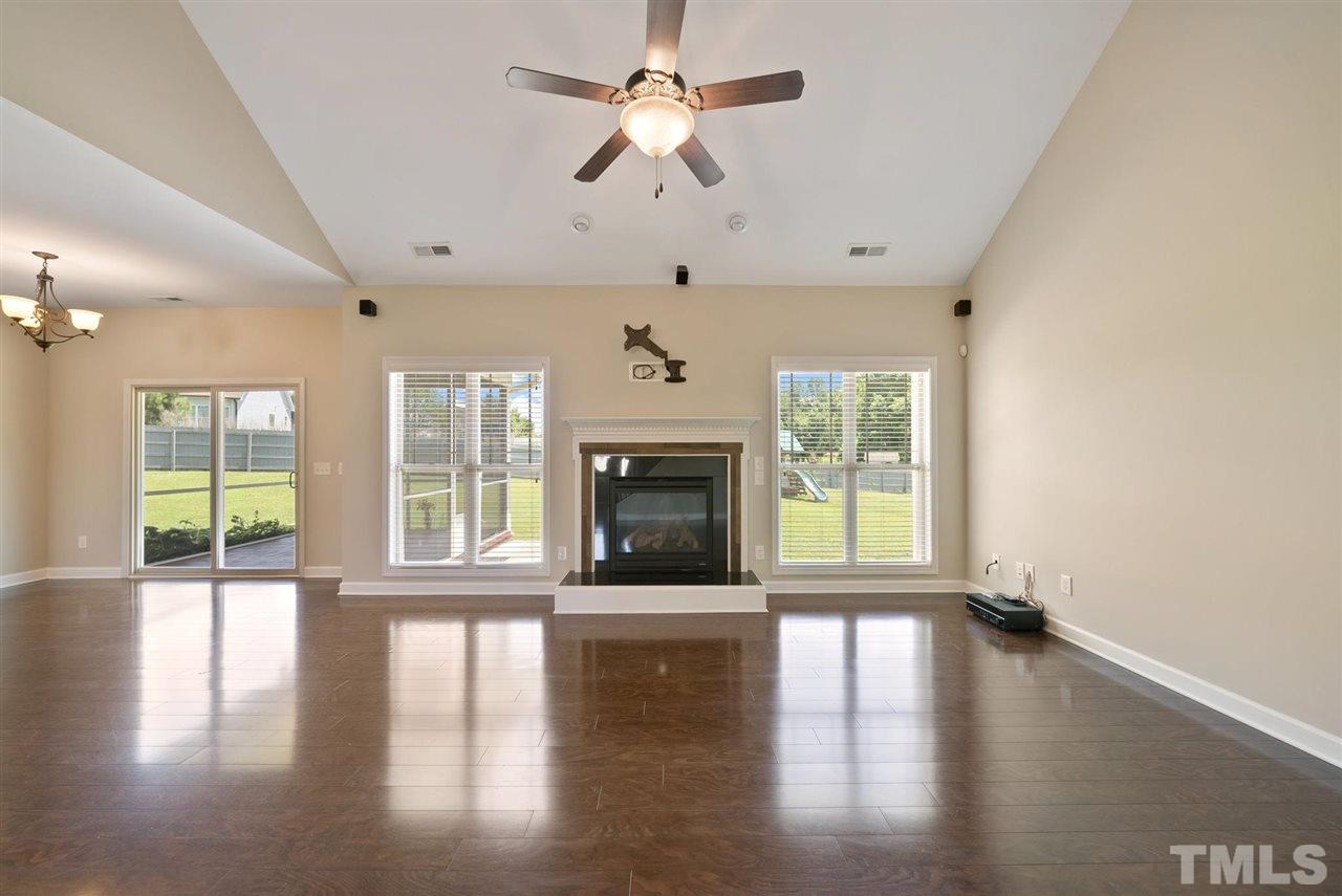 95 South Sunset Ridge Drive Willow Spring, NC 27592 - Photo 12 of 24 a view of an empty room with wooden floor fireplace and a window
