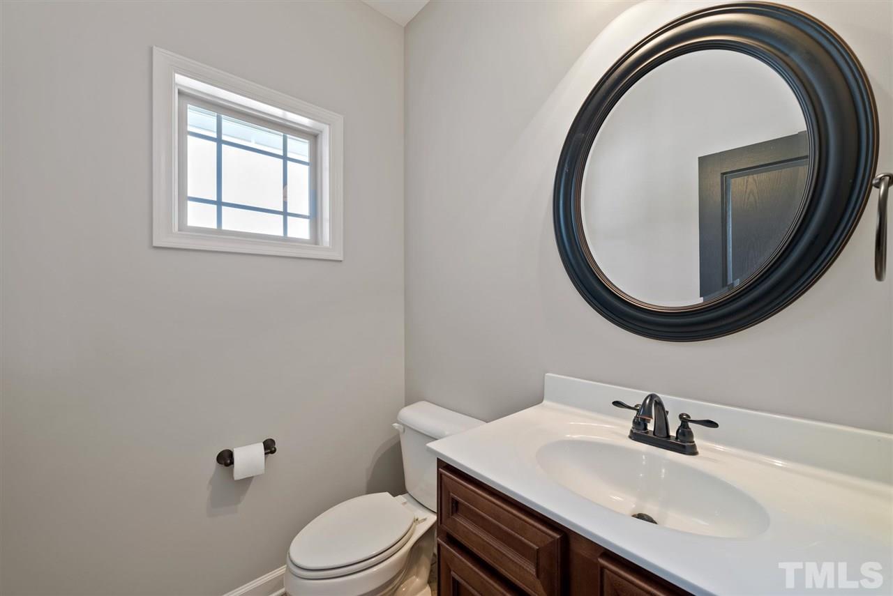 95 South Sunset Ridge Drive Willow Spring, NC 27592 - Photo 17 of 24 a bathroom with a sink a toilet and a mirror