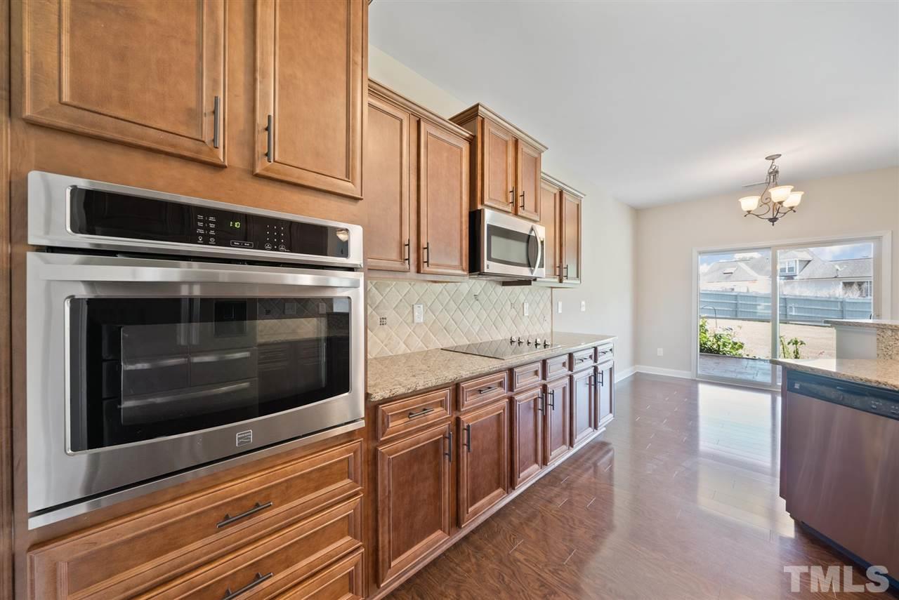 95 South Sunset Ridge Drive Willow Spring, NC 27592 - Photo 10 of 24 a kitchen with stainless steel appliances granite countertop a stove microwave and cabinets