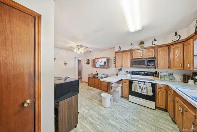 a kitchen with stainless steel appliances granite countertop a stove top oven a sink dishwasher and a refrigerator with wooden floor