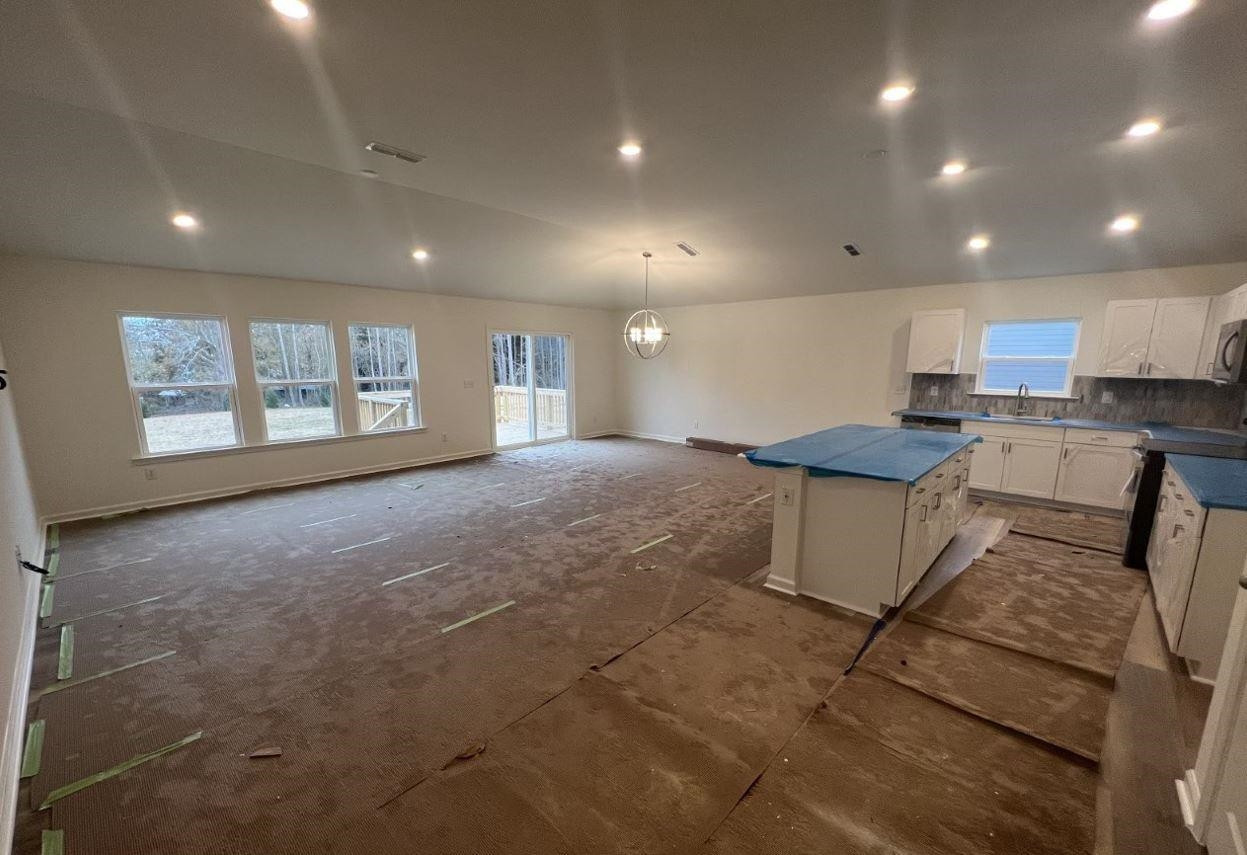 1501 Willow Lndg Way Willow Spring, NC 27592 - Photo 2 of 15 a open kitchen with kitchen island a stove a sink a refrigerator dining table and chairs