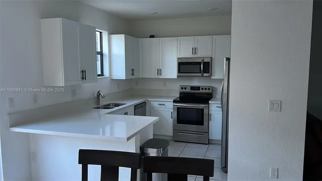 a kitchen with a sink cabinets and stainless steel appliances