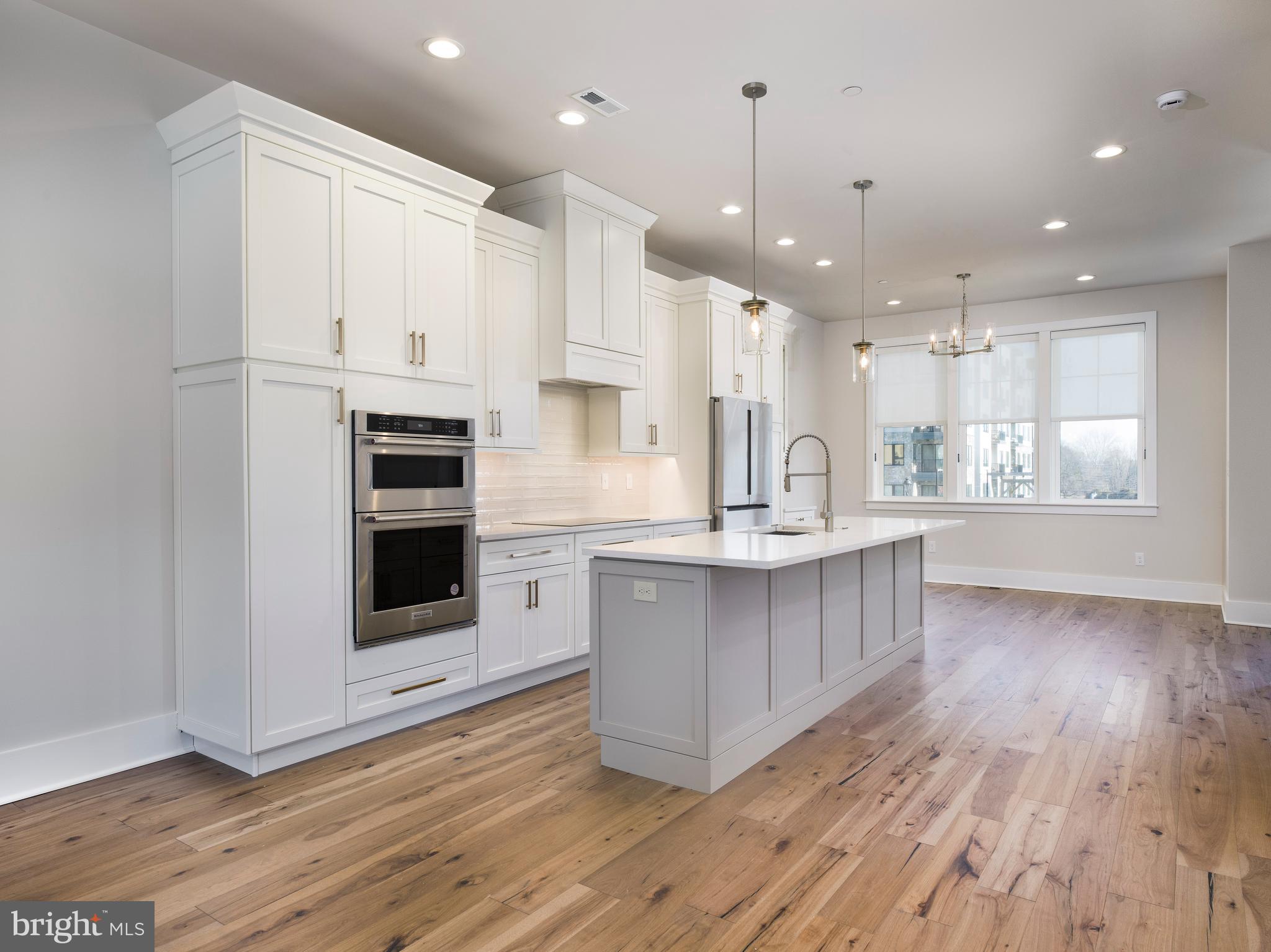 354 Paddock Circle Newtown Square, PA 19073 - Photo 10 of 36 a kitchen with stainless steel appliances kitchen island granite countertop a stove a sink and white cabinets with wooden floor