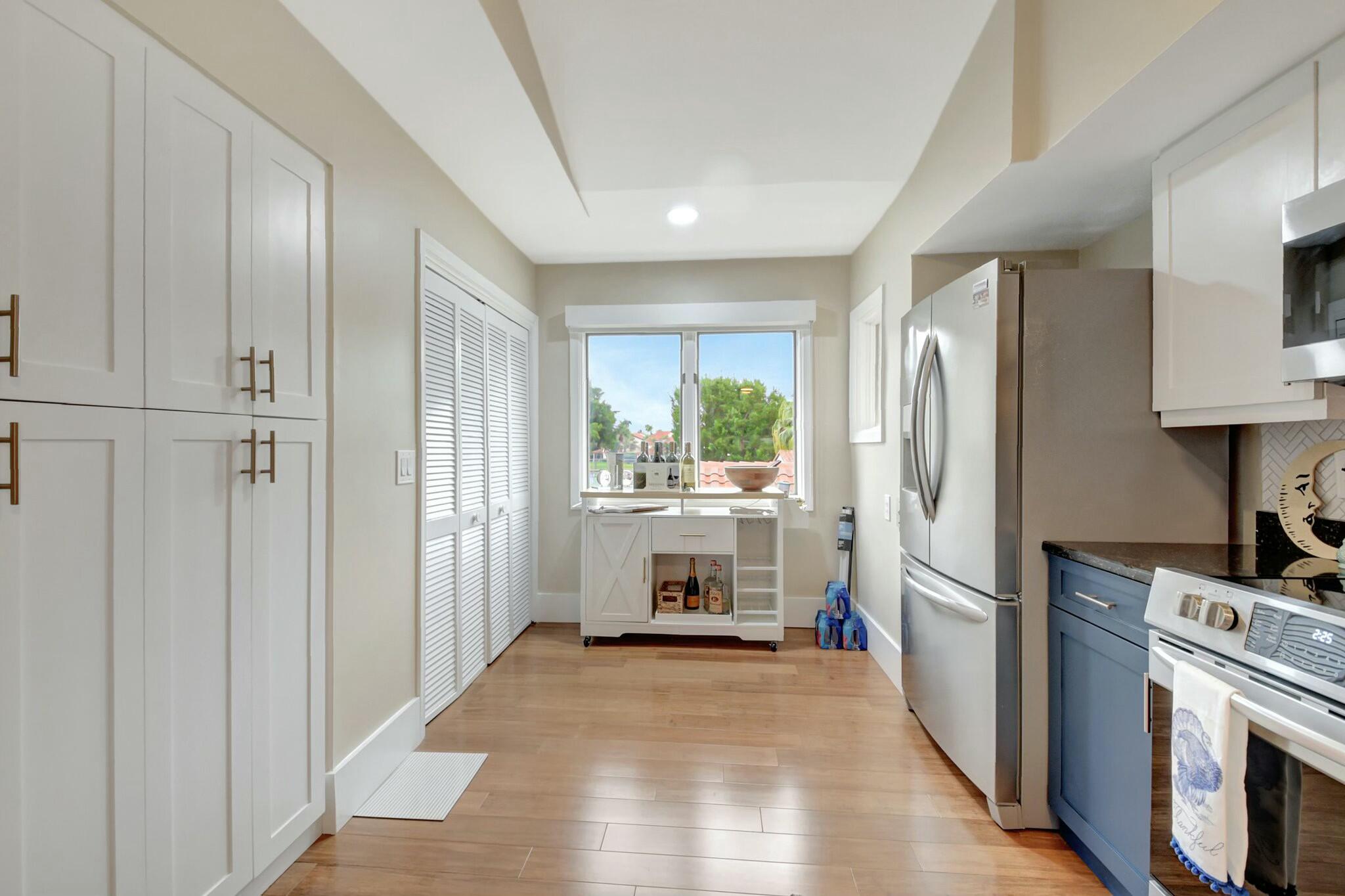 7860 Seville Place, Unit 2202 Boca Raton, FL 33433 - Photo 19 of 30 a kitchen with a refrigerator a stove top oven and cabinets