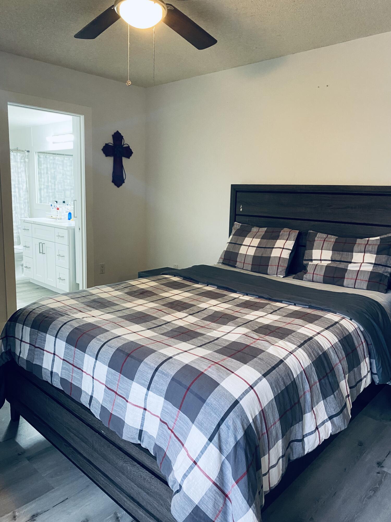 5808 58th Way West Palm Beach, FL 33409 - Photo 14 of 23 a bedroom with a bed and a chandelier