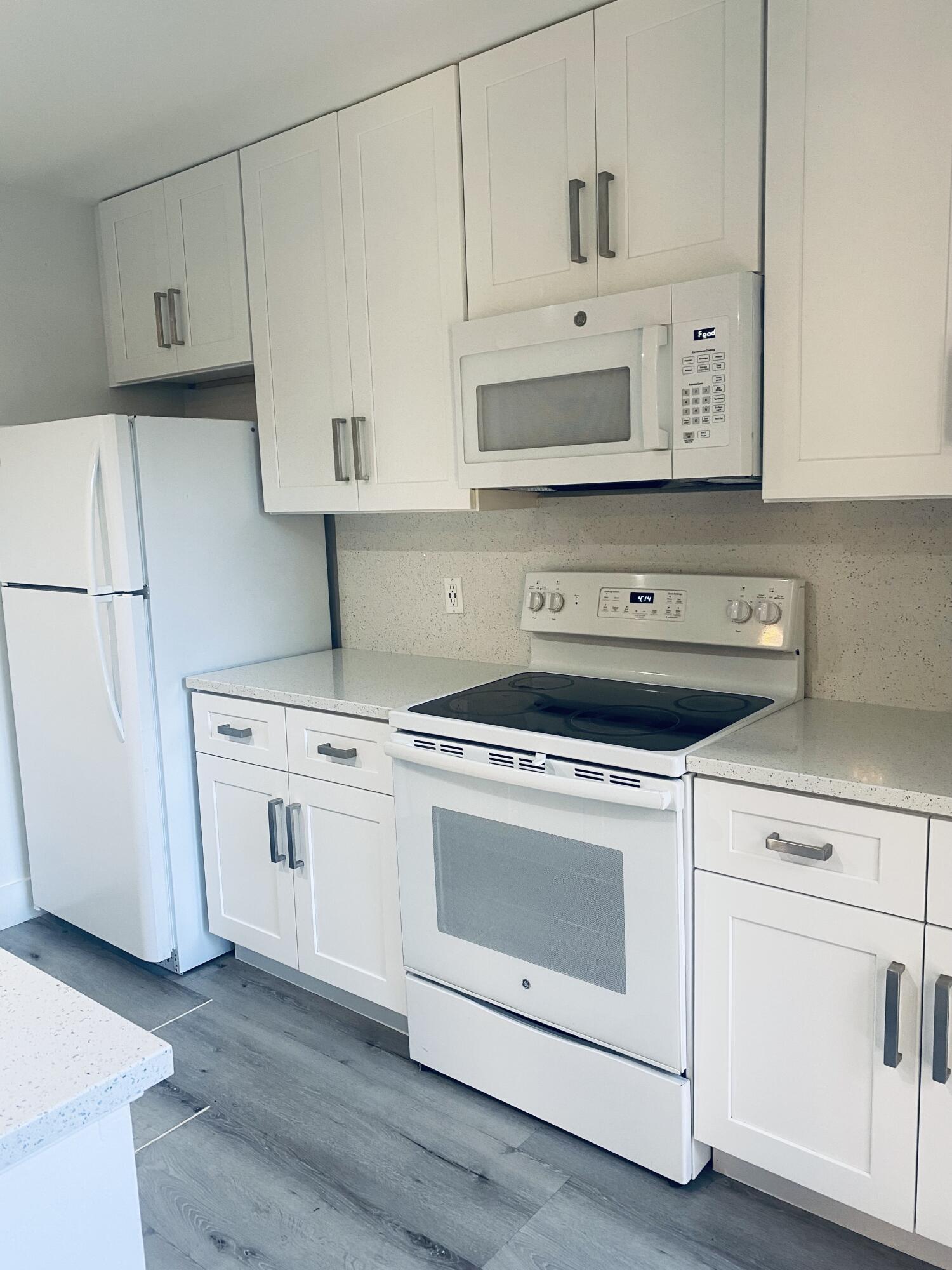 5808 58th Way West Palm Beach, FL 33409 - Photo 7 of 23 a kitchen with white cabinets and white appliances