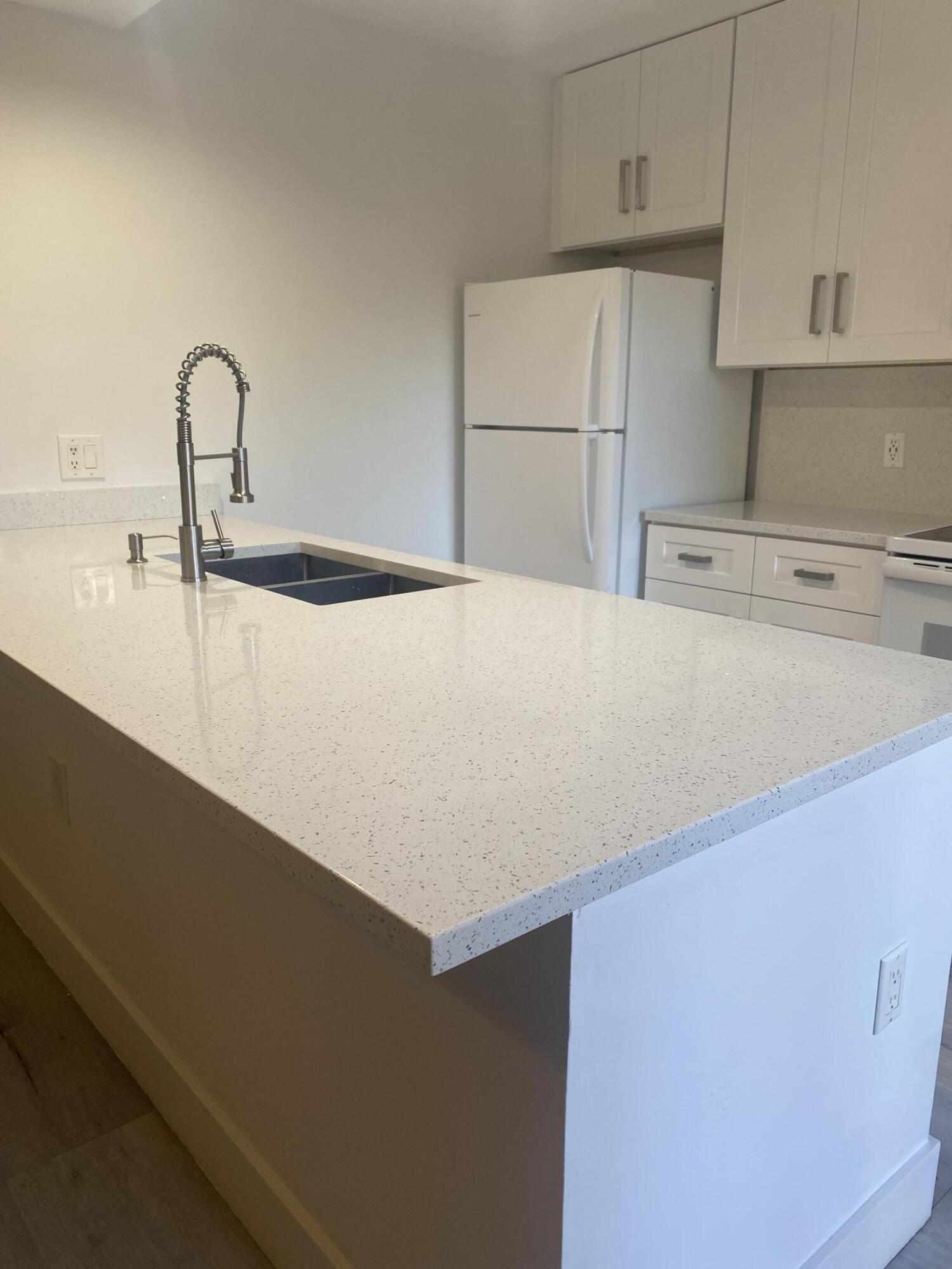 5808 58th Way West Palm Beach, FL 33409 - Photo 8 of 23 a kitchen with a sink a stove and a refrigerator