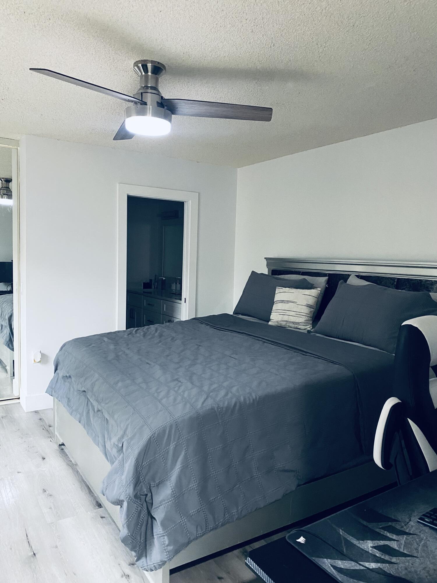 5808 58th Way West Palm Beach, FL 33409 - Photo 9 of 23 a bedroom with a bed and a chandelier