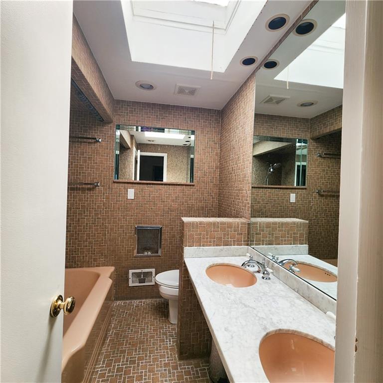 2417 Marbury Road Pittsburgh, PA 15221 - Photo 21 of 31 a bathroom with a granite countertop sink a mirror and bathtub
