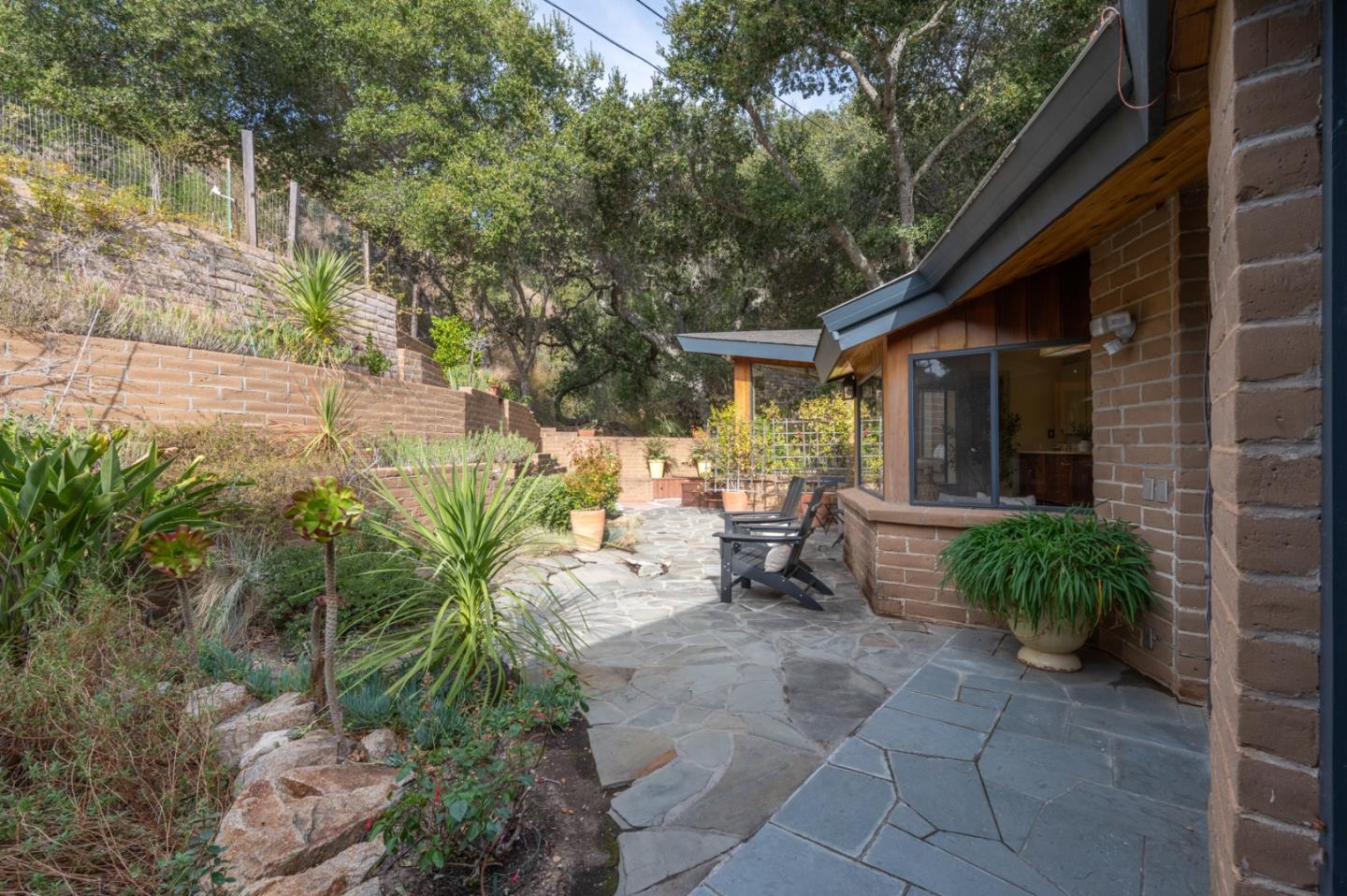 9 Story Road Carmel Valley, CA 93924 - Photo 47 of 60 a view of a patio with table and chairs potted plants and large tree