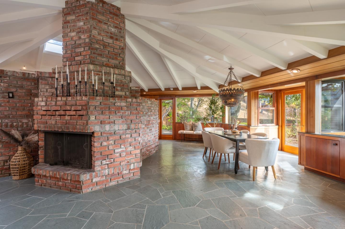 9 Story Road Carmel Valley, CA 93924 - Photo 10 of 60 a living room with furniture a fireplace and a dining table with wooden floor