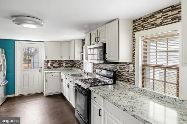 a kitchen with stainless steel appliances granite countertop a stove and a refrigerator