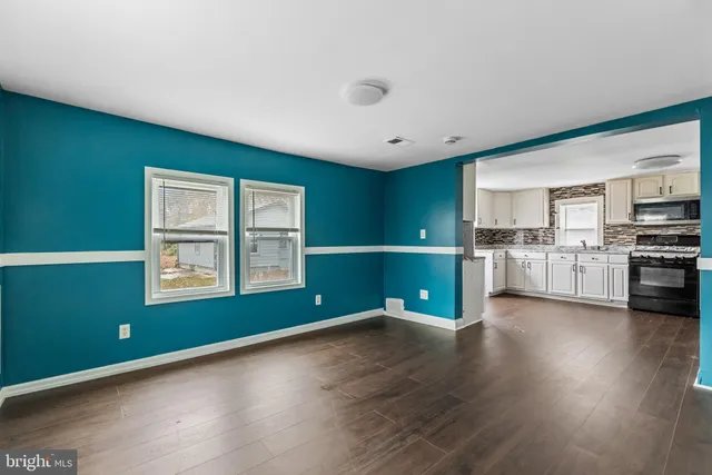 a room with stainless steel appliances wooden floors and view living room