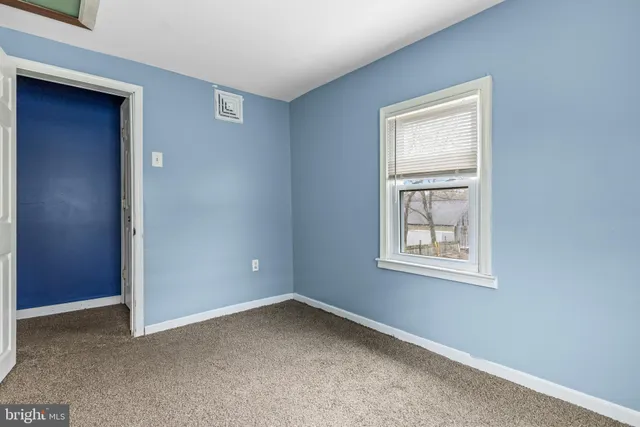 an empty room with windows and closet