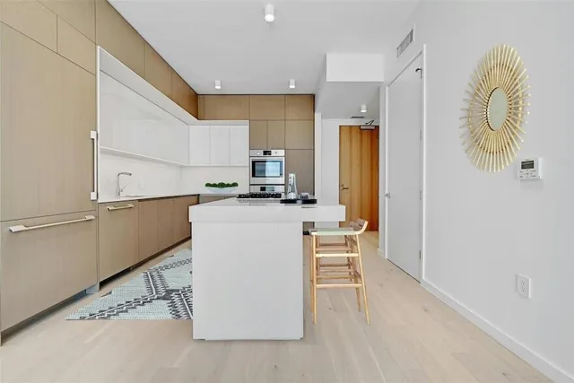 a kitchen with a sink a counter top space stainless steel appliances and cabinets