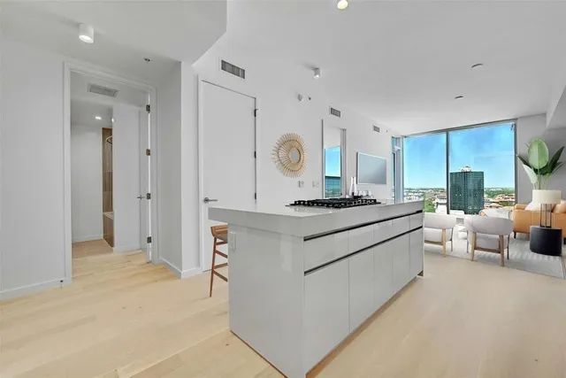 a large white kitchen with a large window