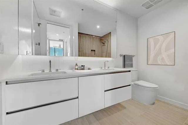 a bathroom with a sink toilet and a mirror