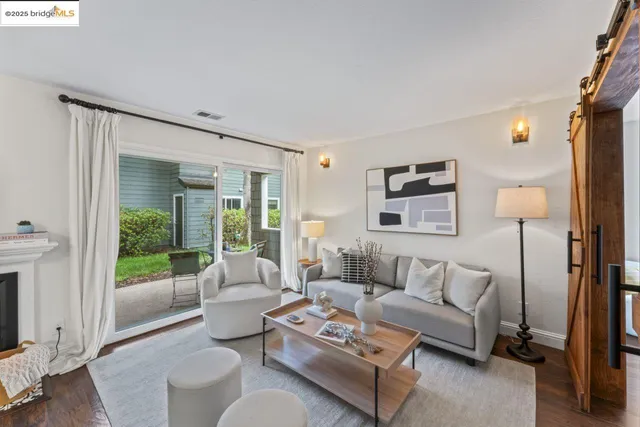 a living room with furniture a fireplace and a floor to ceiling window
