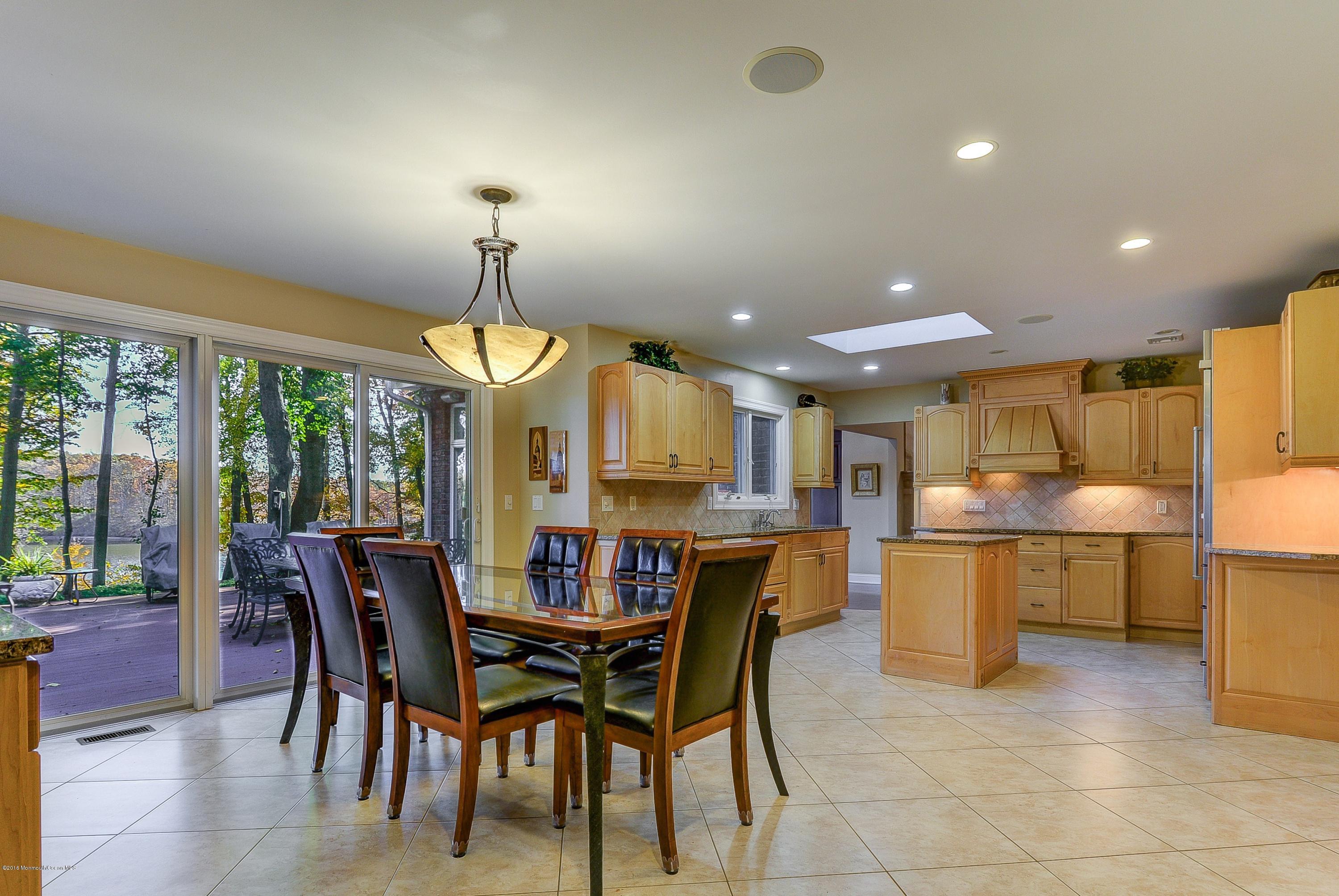 31 Beaver Dam Road Colts Neck, NJ 07722 - Photo 19 of 54 a dining area with a table chairs and a kitchen view