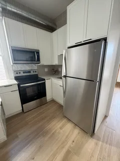 a kitchen with a refrigerator a stove top oven a sink and a refrigerator